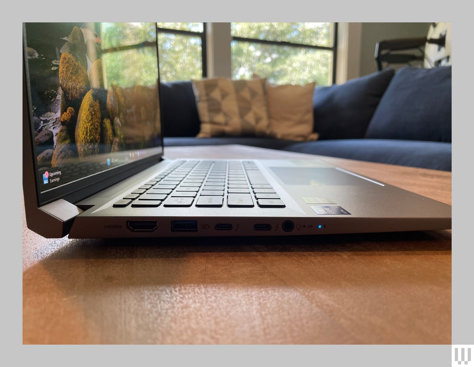 Side view of a silver laptop with the screen open about 90degrees showing the ports along the side