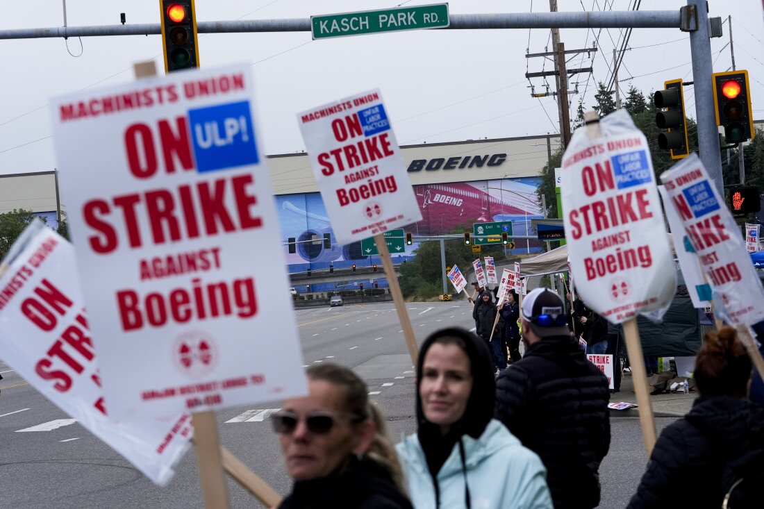 Boeing workers wave picket signs as they strike after union members voted to reject a contract offer, Sunday, Sept. 15, 2024, near the company's factory in Everett, Wash.