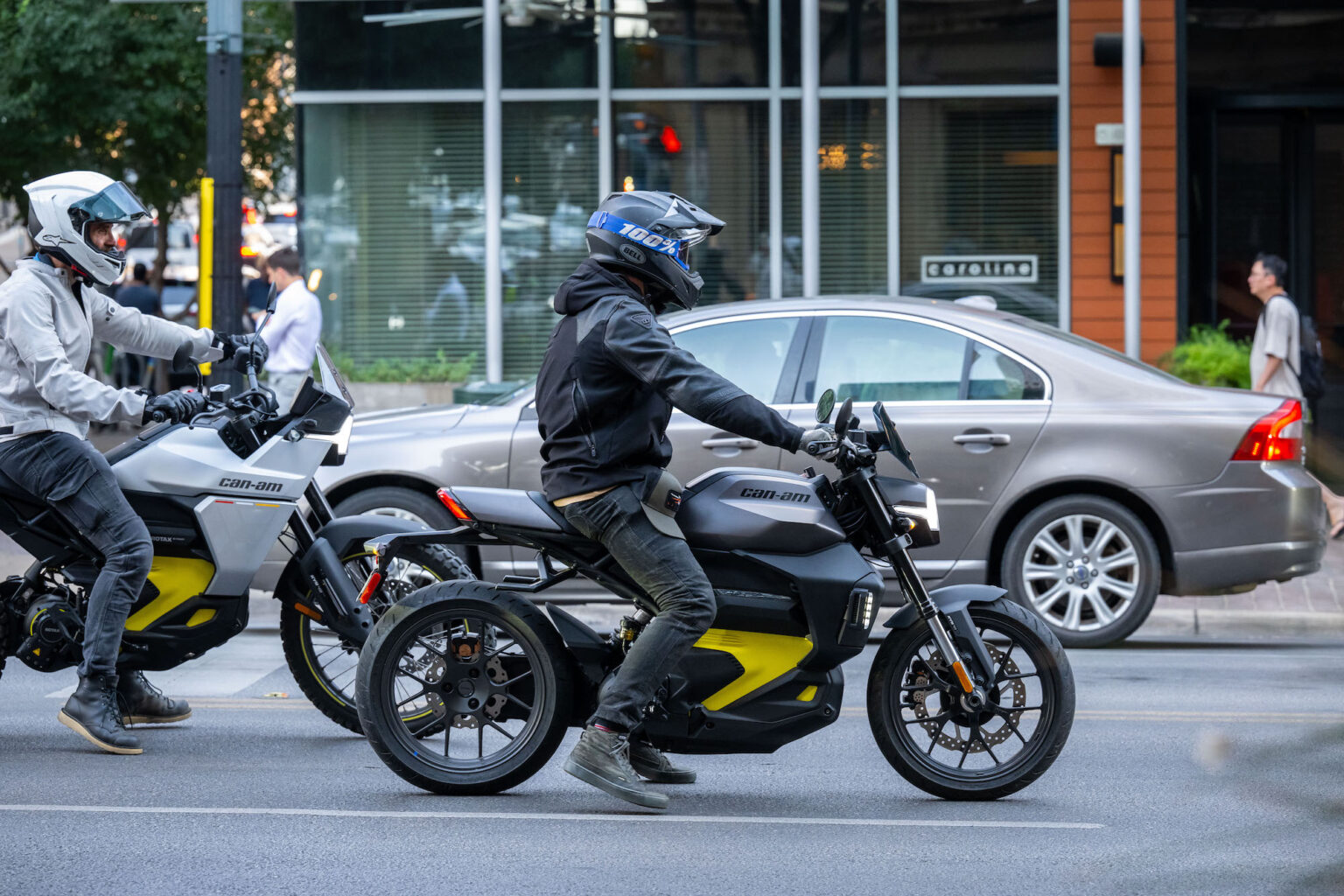 two people on motorcycles on a city street