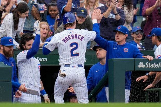 Cubs manager Craig Counsell, right, high-fives Nico Hoerner after Hoerner scored in the fifth inning against the Reds on Sept. 27, 2024, at Wrigley Field. (Erin Hooley/AP)