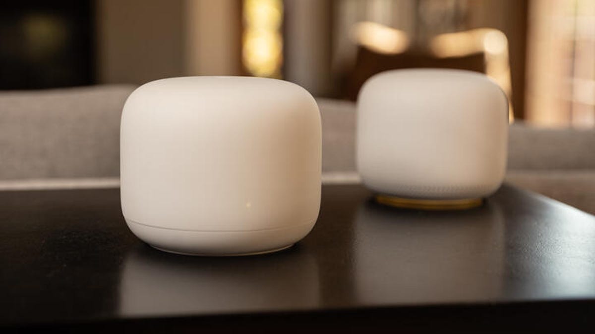 two Google Nest Wifi routers on a dark table