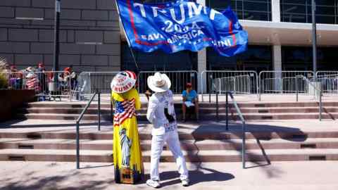 Donald Trump supporters fly a flag at a rally for the former president in Las Vegas, Nevada, this month