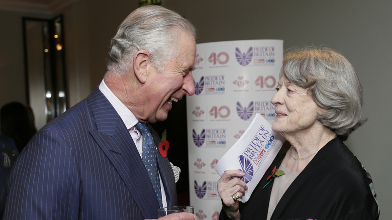 King Charles and Dame Maggie Smith smiling at each other