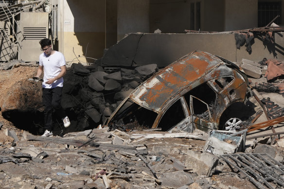 A man walks on rubble at the site of an Israeli airstrike in Beirut’s southern suburbs on Sunday.