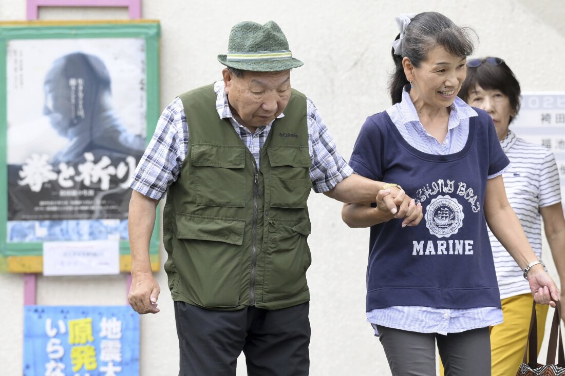 Iwao Hakamada, left, is helped by a supporter as he goes for a walk in Hamamatsu, Shizuoka prefecture, central Japan on Wednesday.