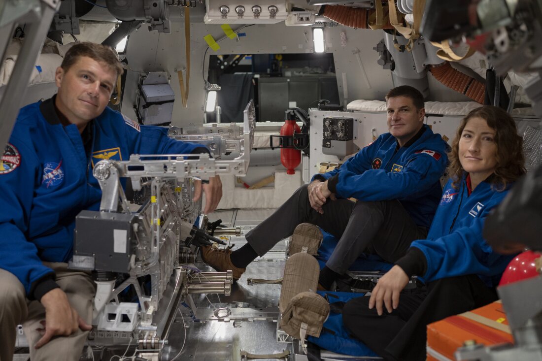 From left to right: Astronauts Reid Wiseman, Artemis II commander, Jeremy Hansen, Artemis II mission specialist, and Christina Koch, Artemis II mission specialist, pose for a portrait inside the Orion spacecraft mockup.