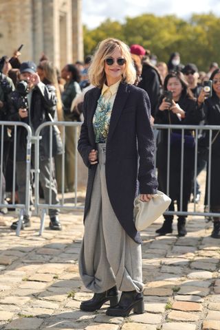 Meg Ryan attends the Loewe show at Paris Fashion Week in fancy Loewe sweatpants and stacked boots