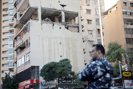 Security personnel stands next to the buildings damaged in an apparent Israeli strike in Beirut.