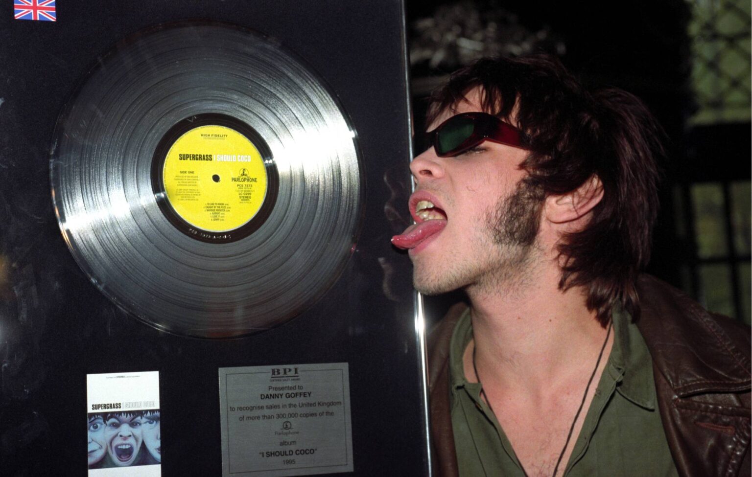 Gaz Coombes of Supergrass licks the platinum disc presented for sales of their album 'I Should Coco' exceeding 300,000 (Photo by Sean Dempsey - PA Images/PA Images via Getty Images)