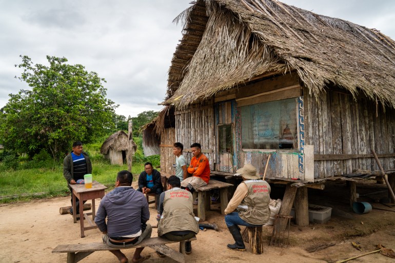 Protection agents meet distressed villagers in Nueva Vida. The presence of isolated tribes here has caused residents to flee homes [Neil Giardino/Al Jazeera]