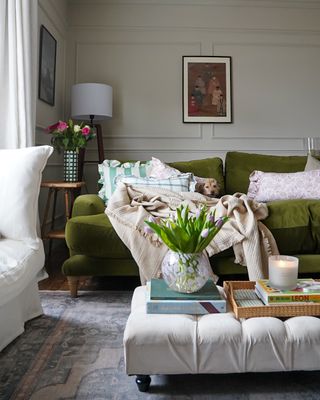 White, eclectic living room with green velvet couch