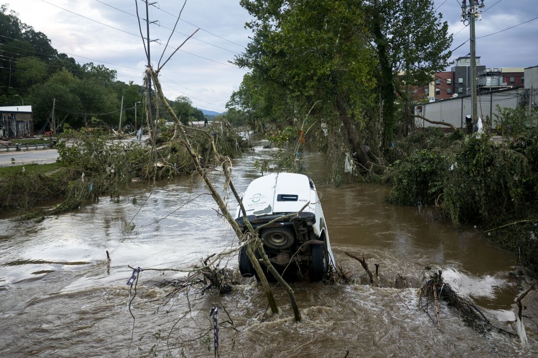 A van is partially submerged in the Swannanoa River in the Biltmore Village in the aftermath of Hurricane Helene on Sunday in Asheville, N.C.