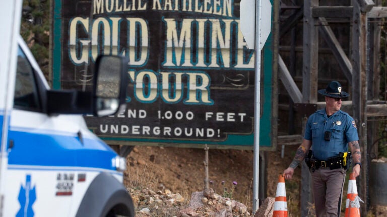 A police officer moves a barrier for an emergency vehicle Thursday, Oct. 9, 2024, at Mollie Kathleen Gold Mine in Cripple Creek, Colo.