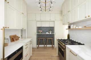 A kitchen with white cabinets that go all the way to the ceiling