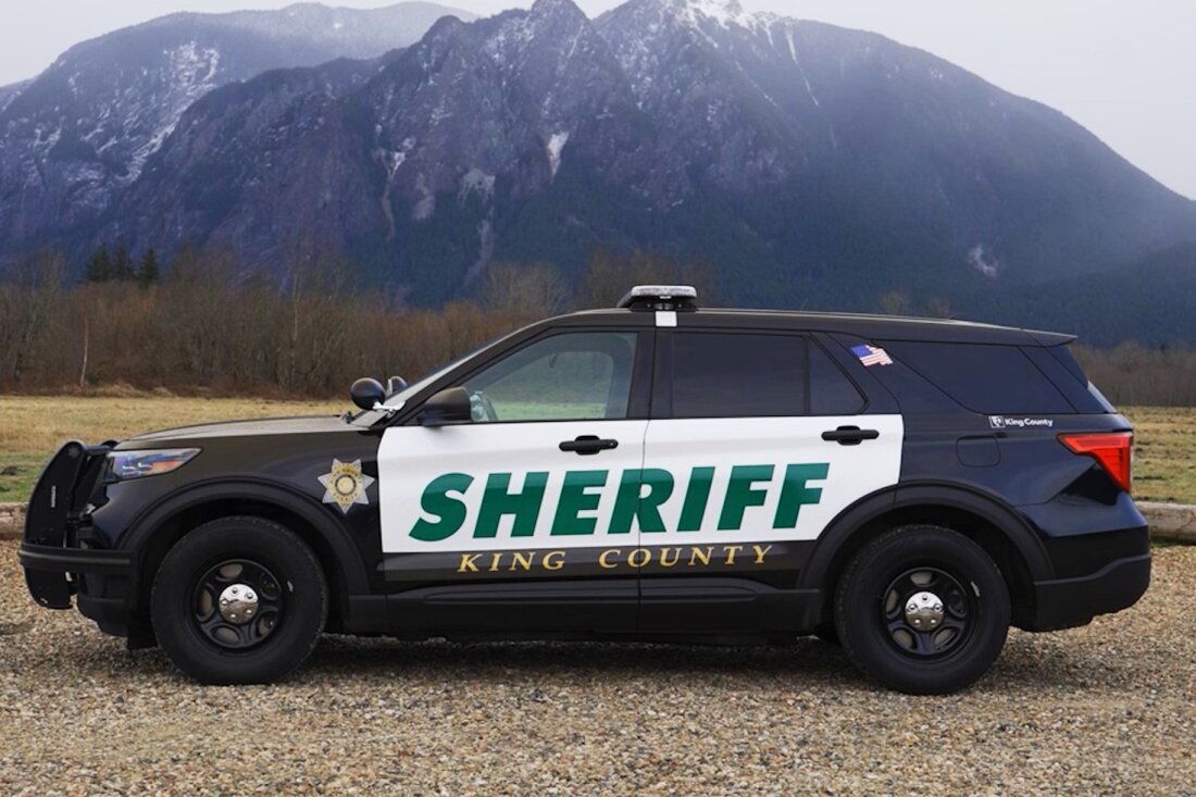 A King County Sheriff's Office car is shown with mountains in the background.