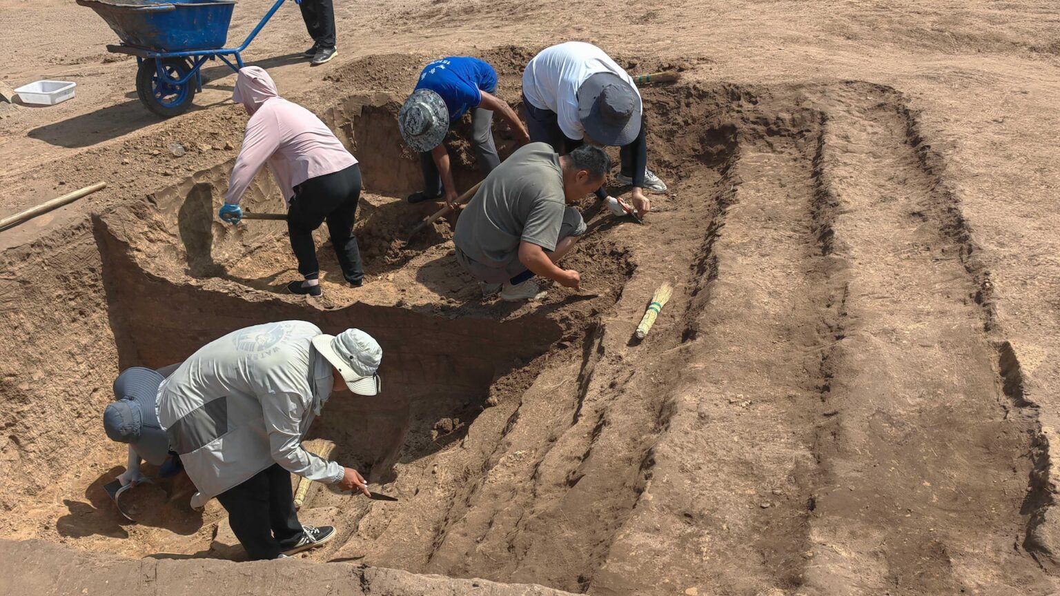 People excavate a dirt pit