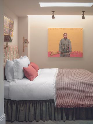 A bedroom with a luxuriously styled bed with white sheets and a red throw