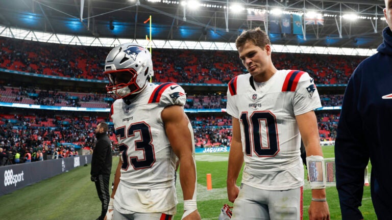 New England Patriots linebacker Christian Elliss (53) and New England Patriots quarterback Drake Maye (10) walk off the field after falling to the Jacksonville Jaguars, 32-16, at Wembley Stadium.