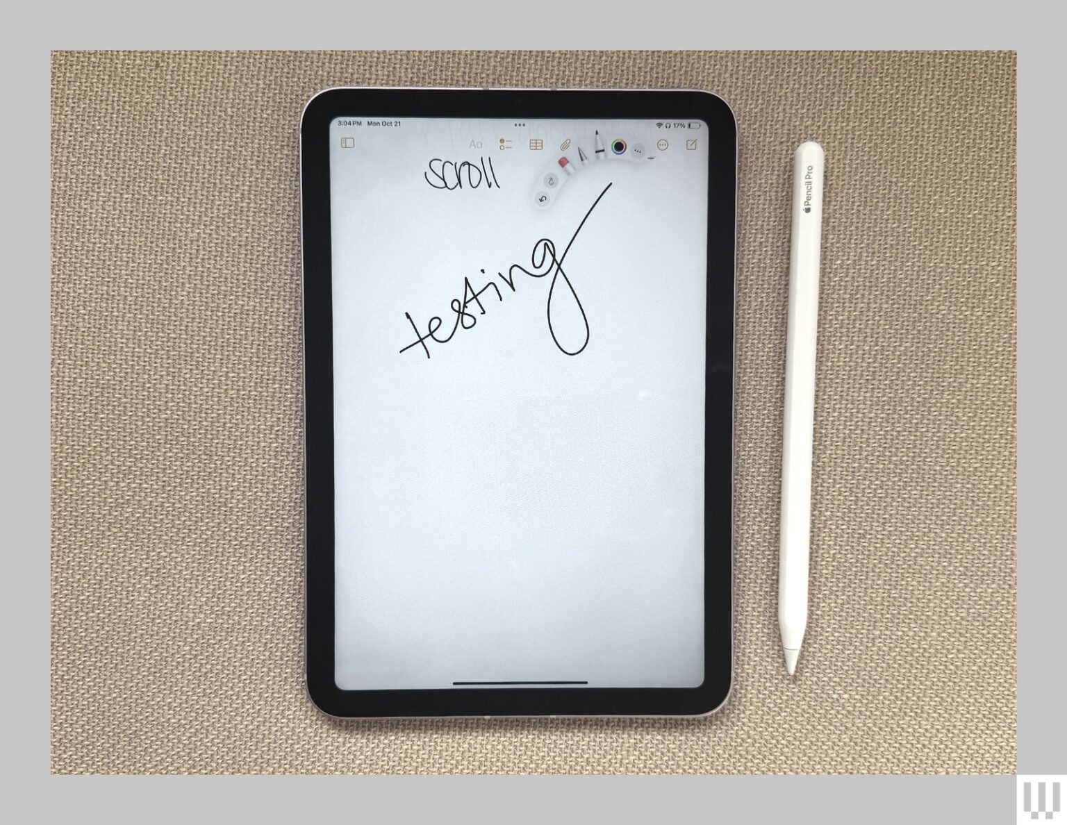 Overhead view of the Apple iPad Mini a slim tablet with the screen showing handwritten scribbles and a stylus  beside it