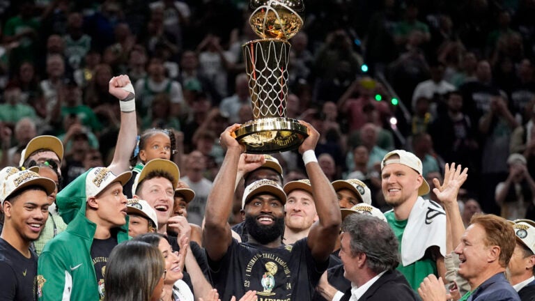 Jaylen Brown holds up the Larry O'Brien Championship Trophy after the Celtics' victory.