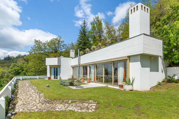 A long, winding driveway leads to the historic residence, which at first glance appears to be only one level. The roof terrace of the house has been converted into a swimming pool.