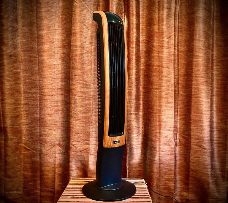 A black and orange lasko tower fan.