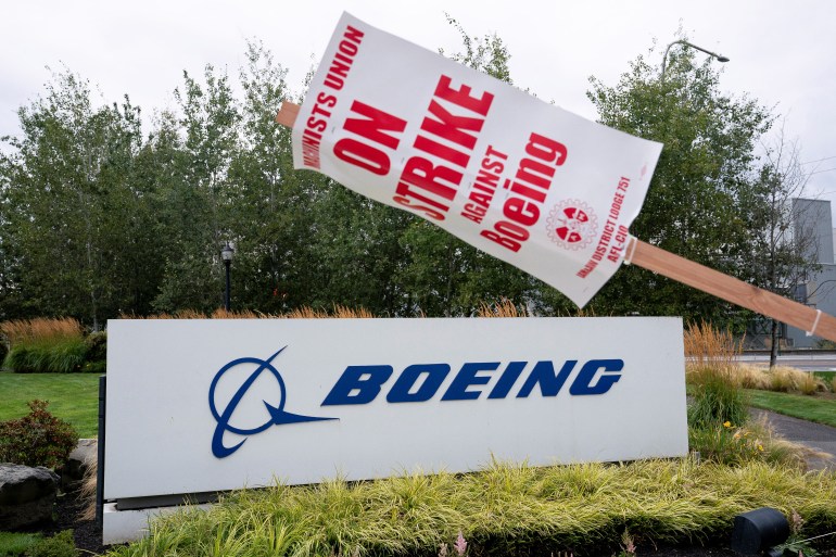 A strike sign hangs from a post near a Boeing sign in Renton, Washington, U.S.