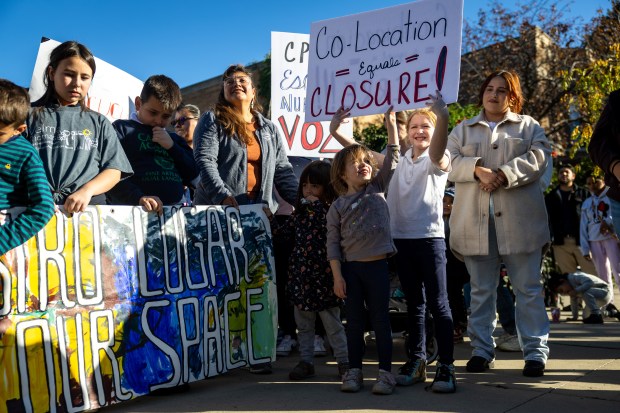 Student Elliot Beedle, 4, left, and former student Lucia Moser, 9, right, hold a sign during a Chicago Teachers Union press conference to protest the relocation of Velma Thomas Early Childhood Center outside the school campus on Oct. 17, 2024. (Tess Crowley/Chicago Tribune)