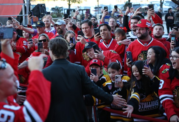 Fans watch as Chicago Blackhawks center Connor Bedard walks the red carpet before the Blackhawks home opener against the San Jose Sharks at the United Center in Chicago on Oct. 17, 2024. (Chris Sweda/Chicago Tribune)