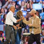 Former President Barack Obama and rapper Eminem embrace during a Kamala Harris campaign rally Tuesday in Detroit.