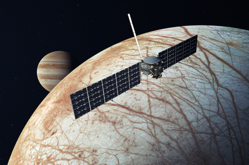 Europa clipper: Spacecraft with large solar panels near moon-like body covered in cracks, and large striped planet in background.