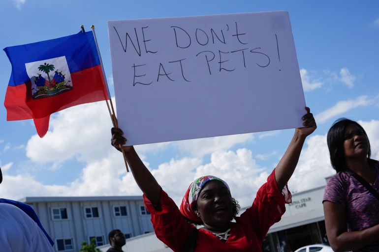 Wilda Brooks of West Palm Beach, Fla., holds up a sign reading "We don't eat pets," during a rally by members of South Florida's Haitian-American community to condemn hate speech and misinformation about Haitian immigrants, Sunday, Sept. 22, 2024, in North Miami, Fla. (AP Photo/Rebecca Blackwell)