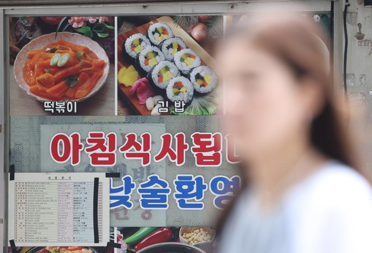 A sign in a restaurant window advertises 'tteokbokki' (steamed rice cake stir-fried in spicy sauce) and gimbap in Seoul, Sept. 11. Yonhap