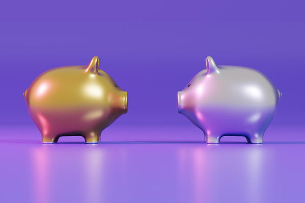 Gold and Silver Piggy Bank Facing Each Other