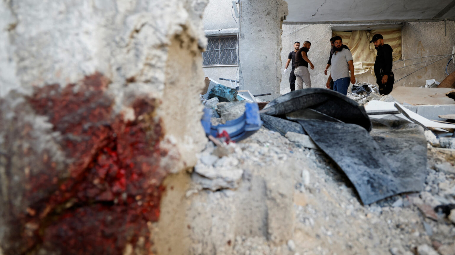 Palestinians inspect the damage at the site of the Israeli air strike (Reuters/Raneen Sawafta)