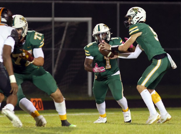 Waubonsie Valley's QB John Siekierski hands the ball to Chrisjan Simmons against Dekalb during a game in Aurora on Friday, Oct. 11, 2024. (James C. Svehla / for the Beacon-News)