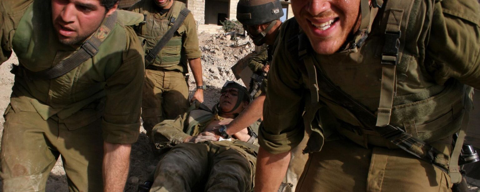 Israeli Army medic Tom Shechter is evacuated by colleagues after the unit came under attack from Hezbollah guerrillas with anti-tank missiles in the village of Inta, outskirts of the southern Lebanon town of  Bint Jbail  early Saturday Aug. 12, 2006.  The unit was clearing routes for armored vehicles and infantry. - Sputnik International, 1920, 30.09.2024