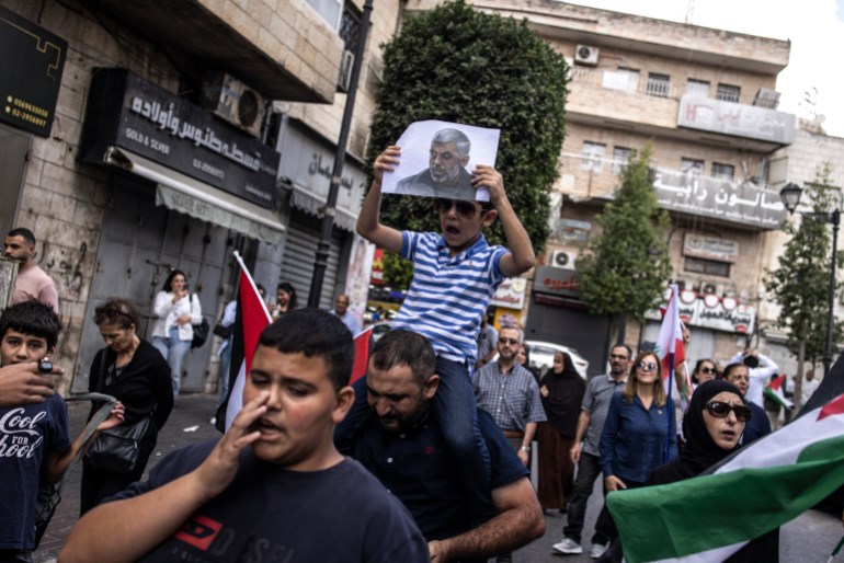 A young Palestinian boy holds up a portrait of slain Hamas leader Yahya Sinwar during a rally in Ramallah, in the Occupie-West Bank on October 18