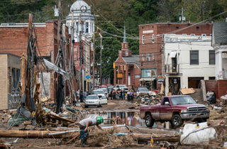 Workers, community members, and business owners clean up debris in the aftermath of Hurricane Helene in Marshall, North Carolina on Monday, Sept. 30, 2024.