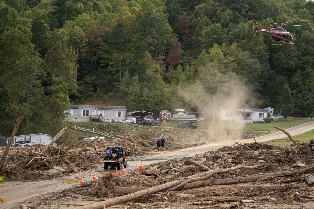 A helicopter lands in a yard in the aftermath of Hurricane Helene on Monday near Black Mountain, N.C.