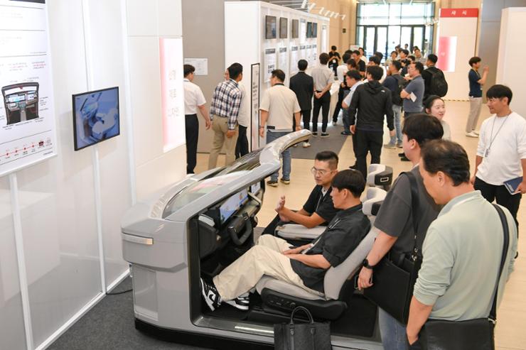 Visitors to Hyundai Mobis' R&D Tech Day event experience the firm's auto parts technologies at its Technical Center in Uiwang, Gyeonggi Province, Wednesday. Courtesy of Hyundai Mobis