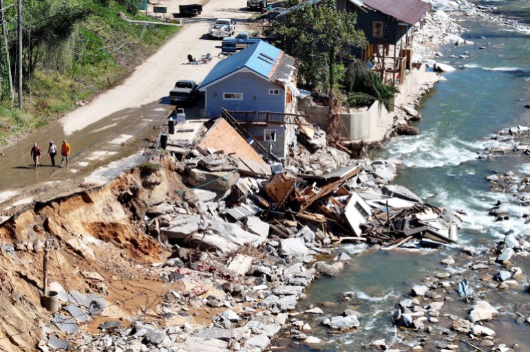 BAT CAVE, NORTH CAROLINA - OCTOBER 08: An aerial view of people walking past destroyed and damaged buildings in the aftermath of Hurricane Helene flooding on October 8, 2024 in Bat Cave, North Carolina. Bate Cave was particularly hard hit by flooding. Recovery efforts continue as the death toll has risen to over 230 while the powerful Hurricane Milton is on track to make landfall in Florida. Mario Tama/Getty Images/AFP (Photo by MARIO TAMA / GETTY IMAGES NORTH AMERICA / Getty Images via AFP)