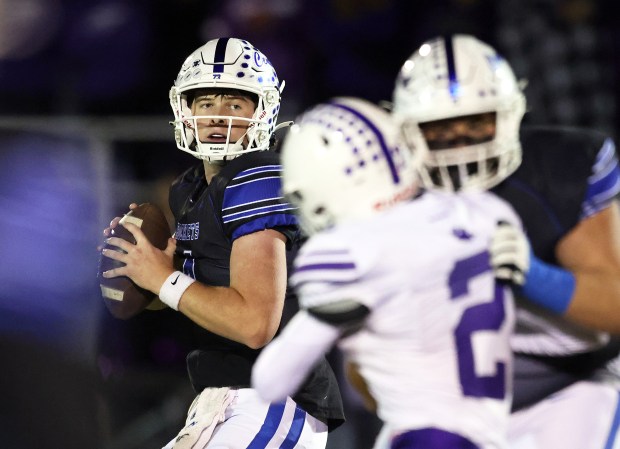 Burlington Central's Jackson Alcorn (4) looks to throw through traffic in the first quarter against Hampshire during a Fox Valley Conference game in Burlington on Friday, Oct. 18, 2024.(H. Rick Bamman / The Beacon-News)