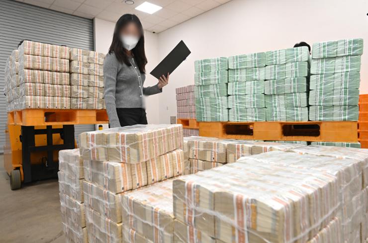 An employee reviews stacks of money to be distributed to local commercial banks ahead of the Chuseok holidays at Bank of Korea's Gyeonggi headquarters in Suwon, Gyeonggi Province, Sept. 10. Yonhap