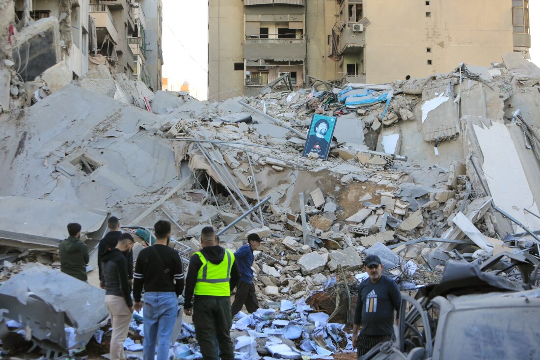 People inspect the damage at the site of an overnight Israeli airstrike that targeted a branch of the Al-Qard Al-Hassan finance group in Beirut's southern suburbs on Monday.