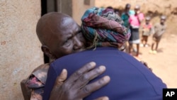 Emelyne Nzeyimana, right, and Prudencienne Namukobwa perform akazehe, a Burundian traditional form of musical greeting performed exclusively by women, outside her home in Ngozi, Burundi, Sept. 20, 2024.