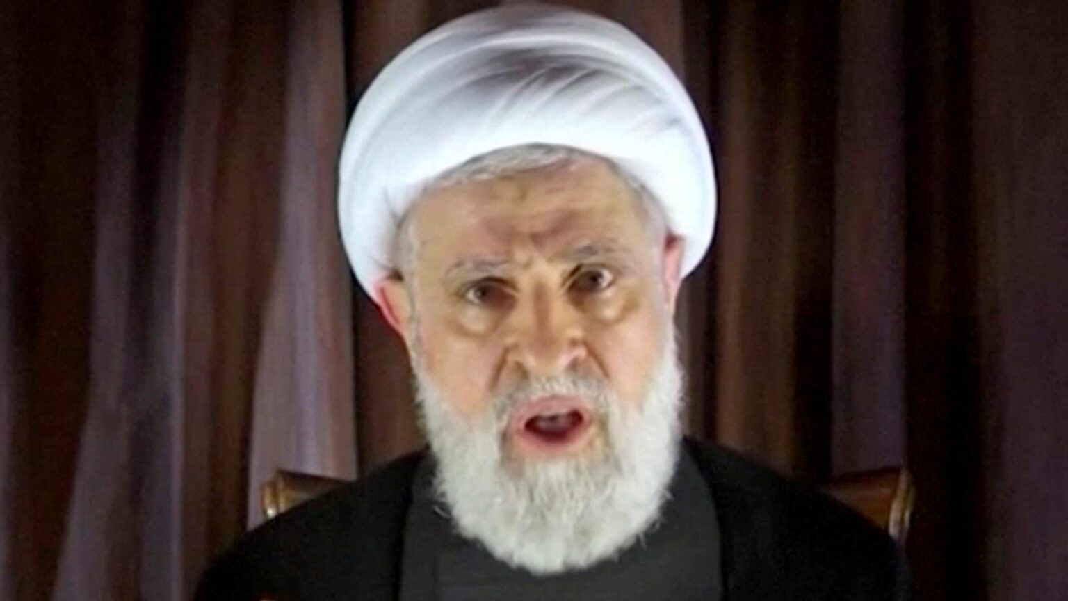 Hezbollah deputy leader Sheikh Naim Qassem delivers a speech from an unknown location, 8 October (ReutersTV/Al Manar TV)