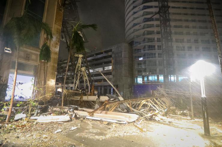 Debris covers the ground near a crane that fell onto a building along 1st Avenue South in St. Petersburg, Fla., Oct. 10. AP-Yonhap