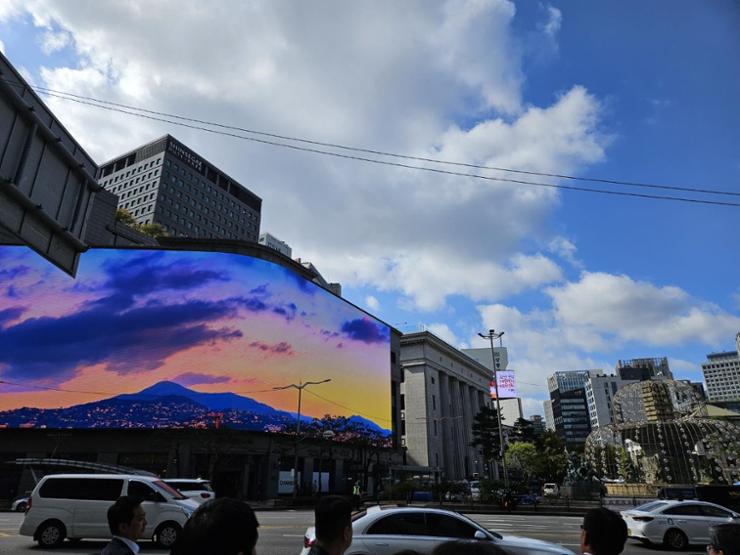 A large media display showcases a short video featuring Korea's natural landscapes and cityscapes on the facade of Shinsegae Department Store’s main building in central Seoul, Wednesday. Korea Times photo by Jung Da-hyun