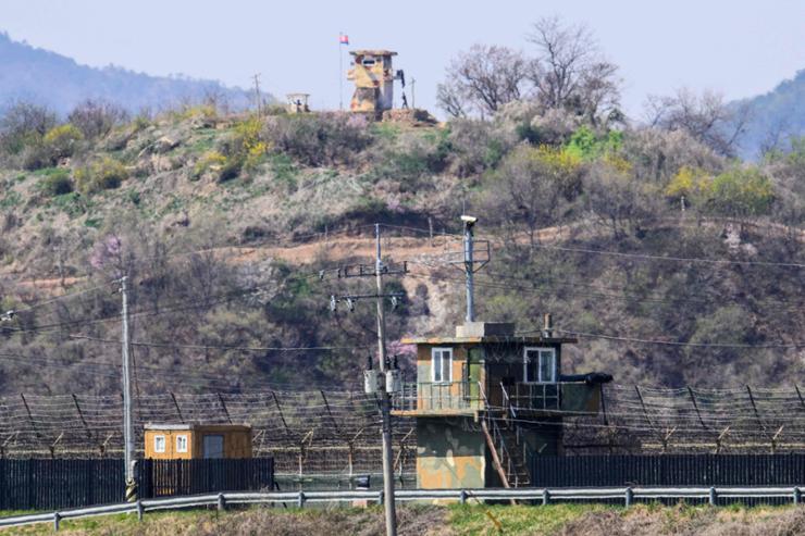 An April 15, 2022 photo from the South Korean border city of Paju shows soldiers (top) outside a guard post in North Korea, as seen beyond a South Korean guard post (bottom). AFP-Yonhap